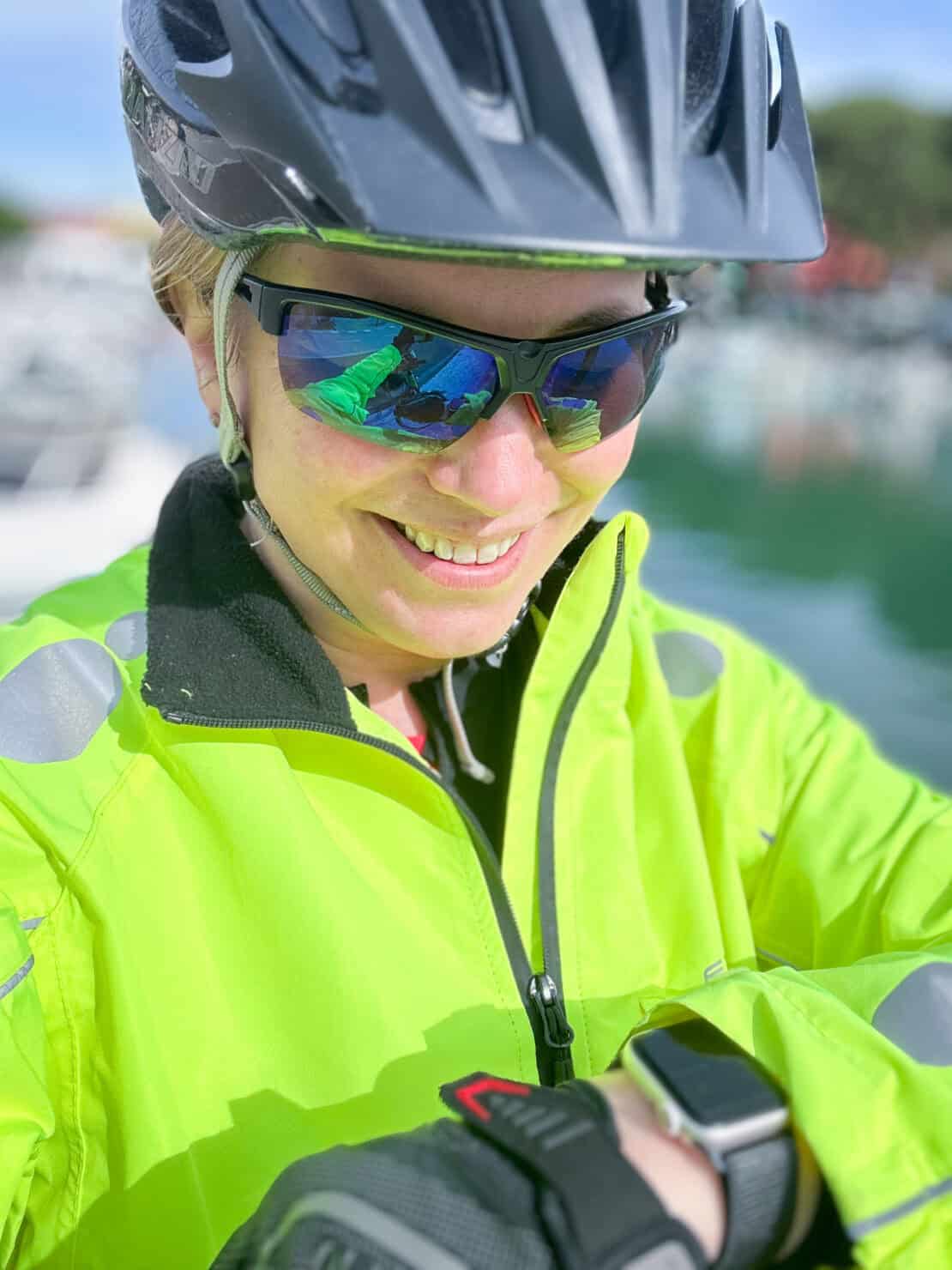 Abigail King checking smart watch Gentler app in fluorescent yellow cycling gear