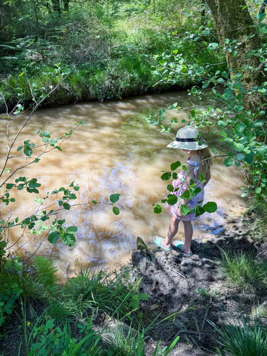 Girl paddling in the brook in Wenchford, Forest of Dean, England