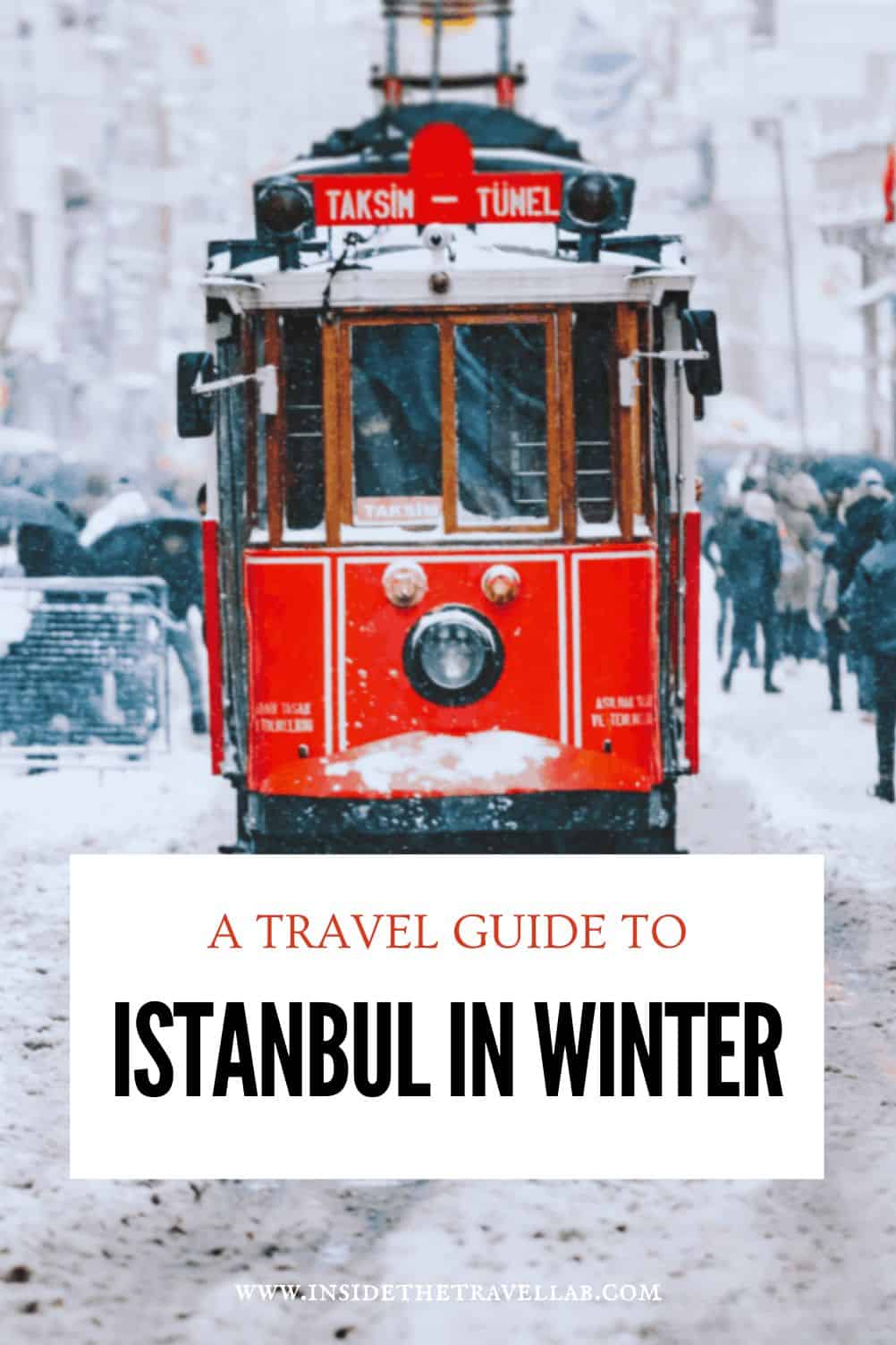 Red historic tram covered in snow on Istanbul's Istiklal Street during winter, with pedestrians walking through the snowy street