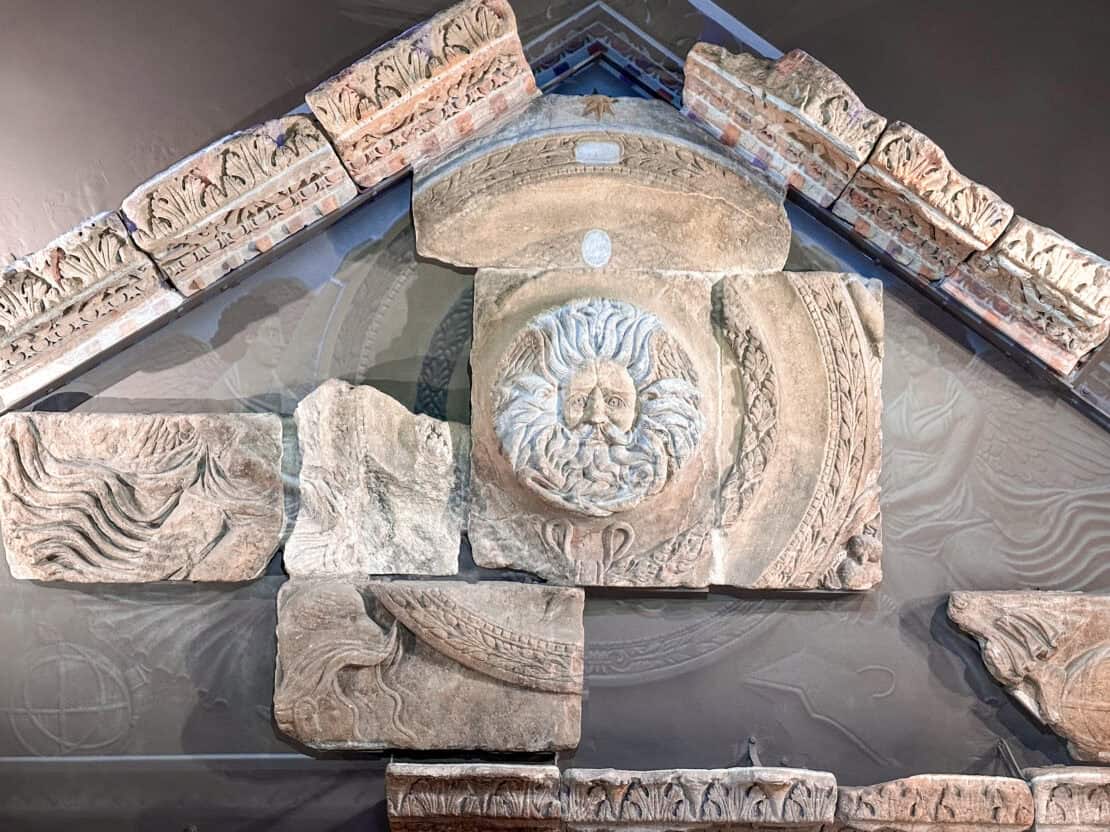 Stone head of Gorgon in ruined pediment from bath Spa