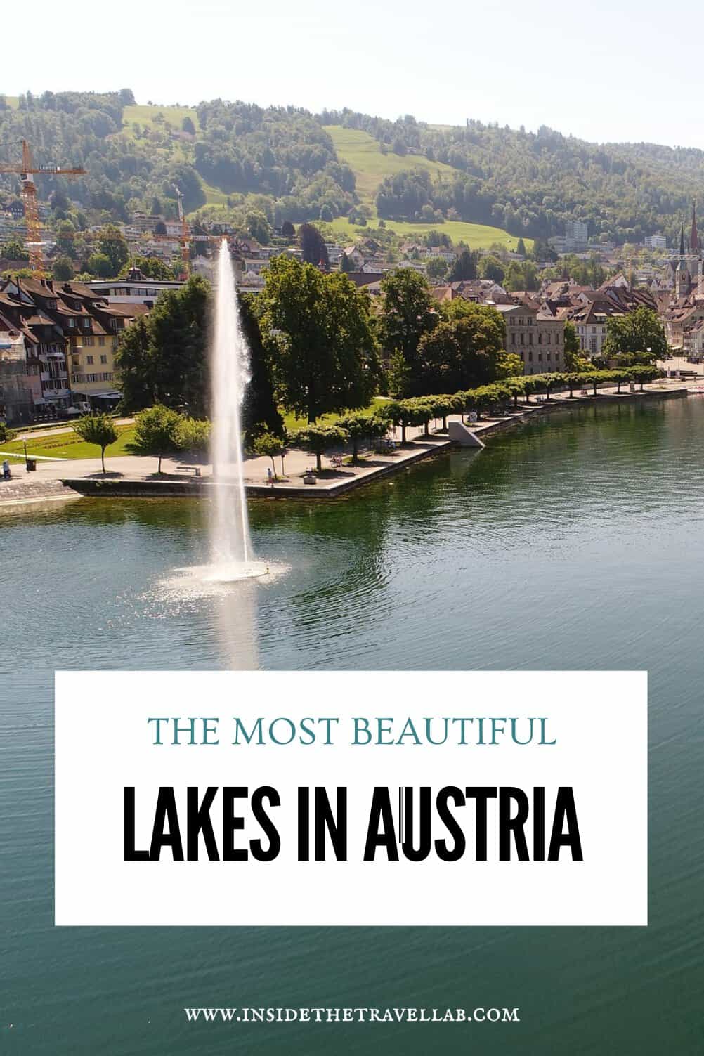 View across Lake Lucerne in Switzerland with a fountain in the water, a tree-lined waterfront and green hills beyond